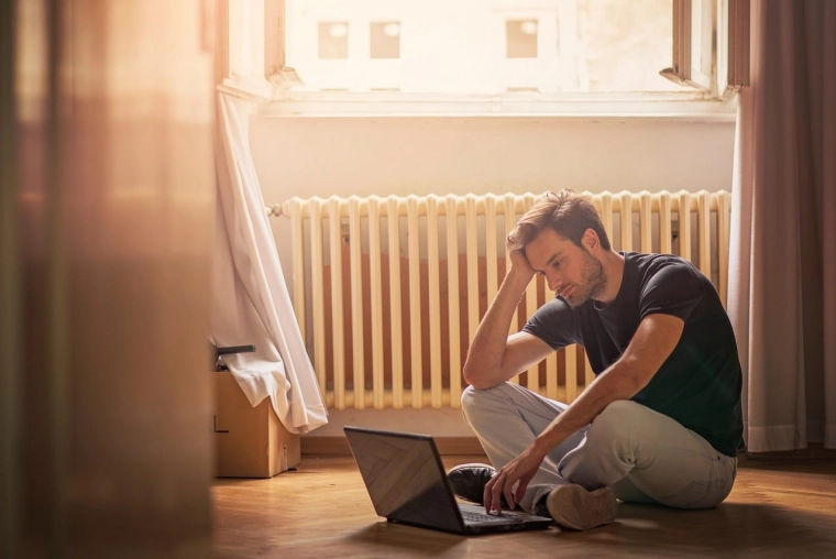 Etudiant assis au tailleur au sol