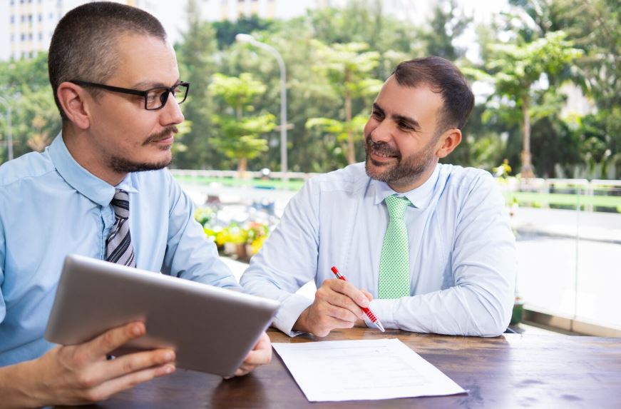 Un consultant portant une cravate verte échange de manière dynamique avec son interlocuteur