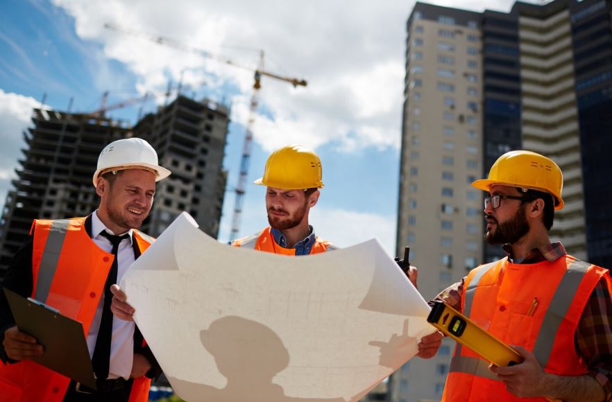 Équipe de professionnels analysant des plans sur un chantier de construction