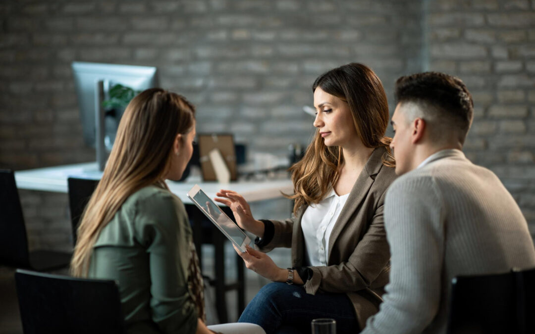Conseillère présentant des solutions diversifiées sur tablette à un couple.